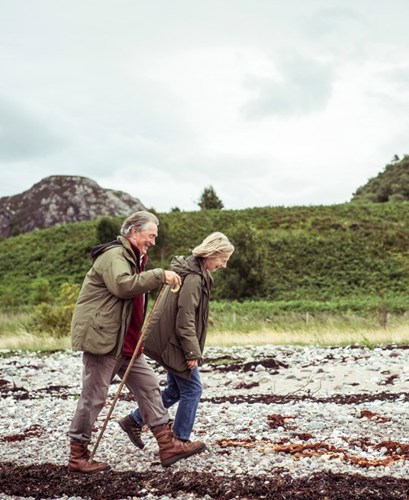 An elderly couple walking along a breach in Scotland